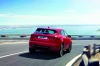 Driving 2019 Jaguar E-Pace P300 R-Dynamic AWD in Firenze Red Metallic from a rear right view